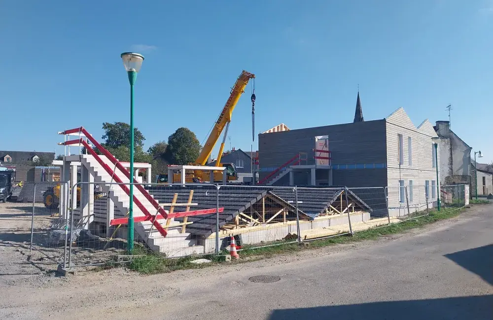 Chantier construction avec fermettes au sol et tuiles posées