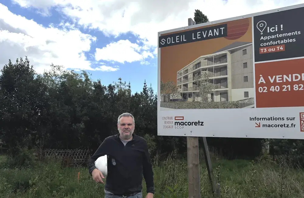 conduteur de travaux devant le panneau de l'habitat participatif soleil levant saint nazaire