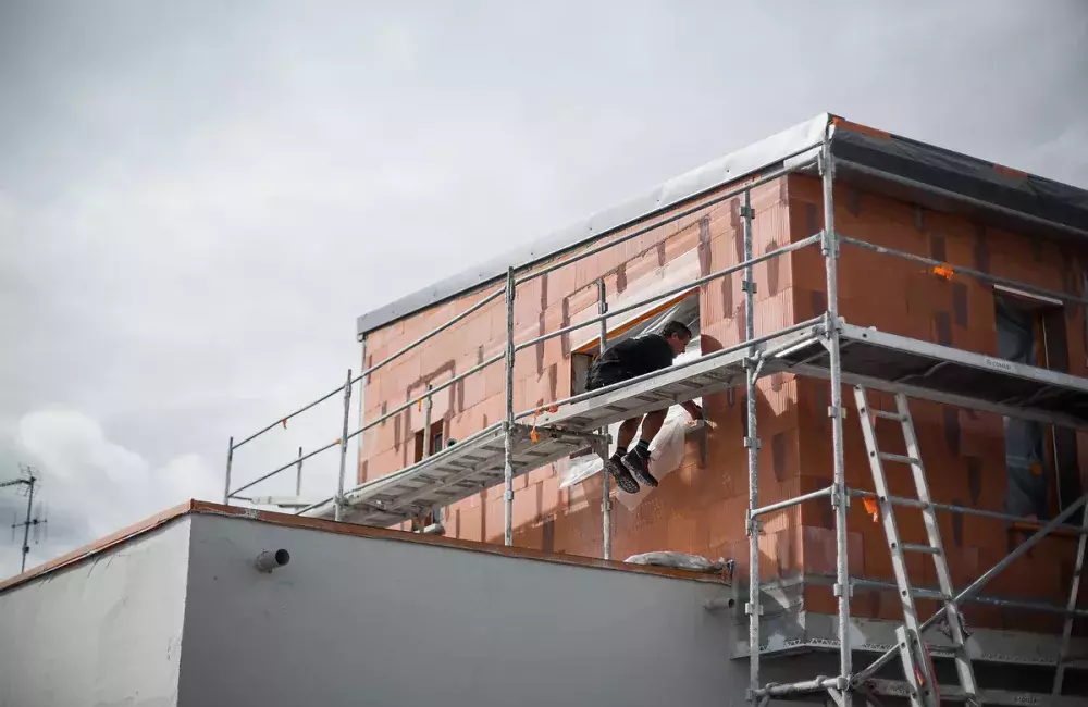 salarie-travail-hauteur-maison-briques-chauve
